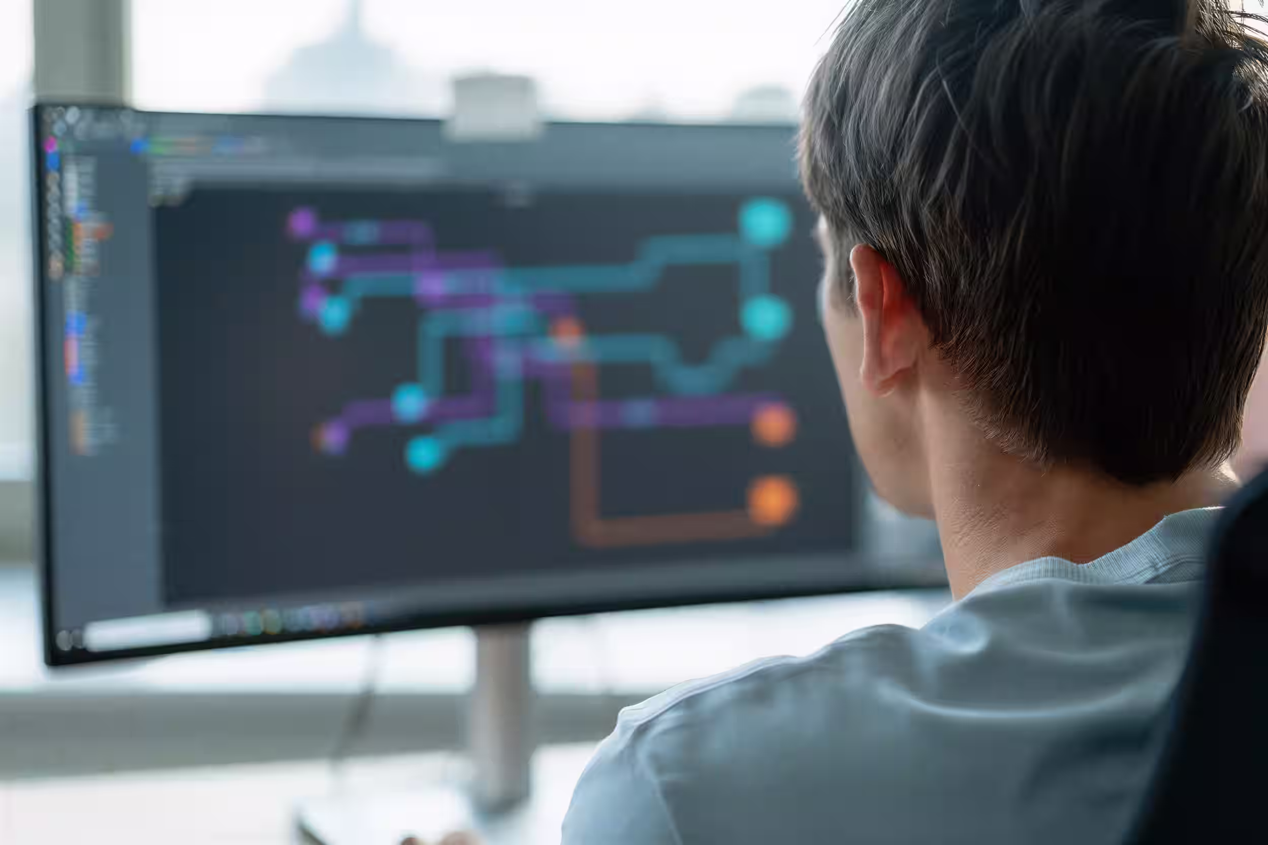 Person looking at a computer screen displaying a colourful AI automation workflow process diagram.